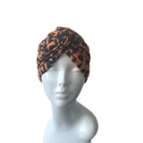 Patterned orange and black twist turban hat for women.